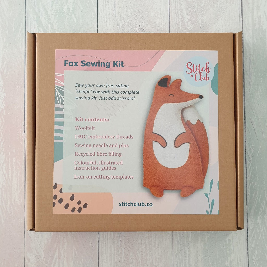 A sewing kit box with a colourful sticker featuring a felt fox