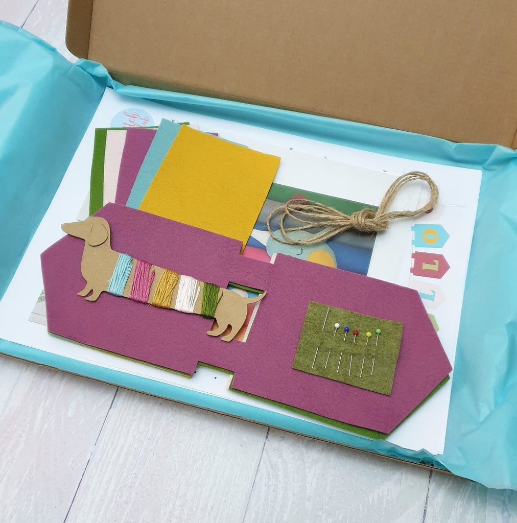 An open box displaying the items in a sewing kit