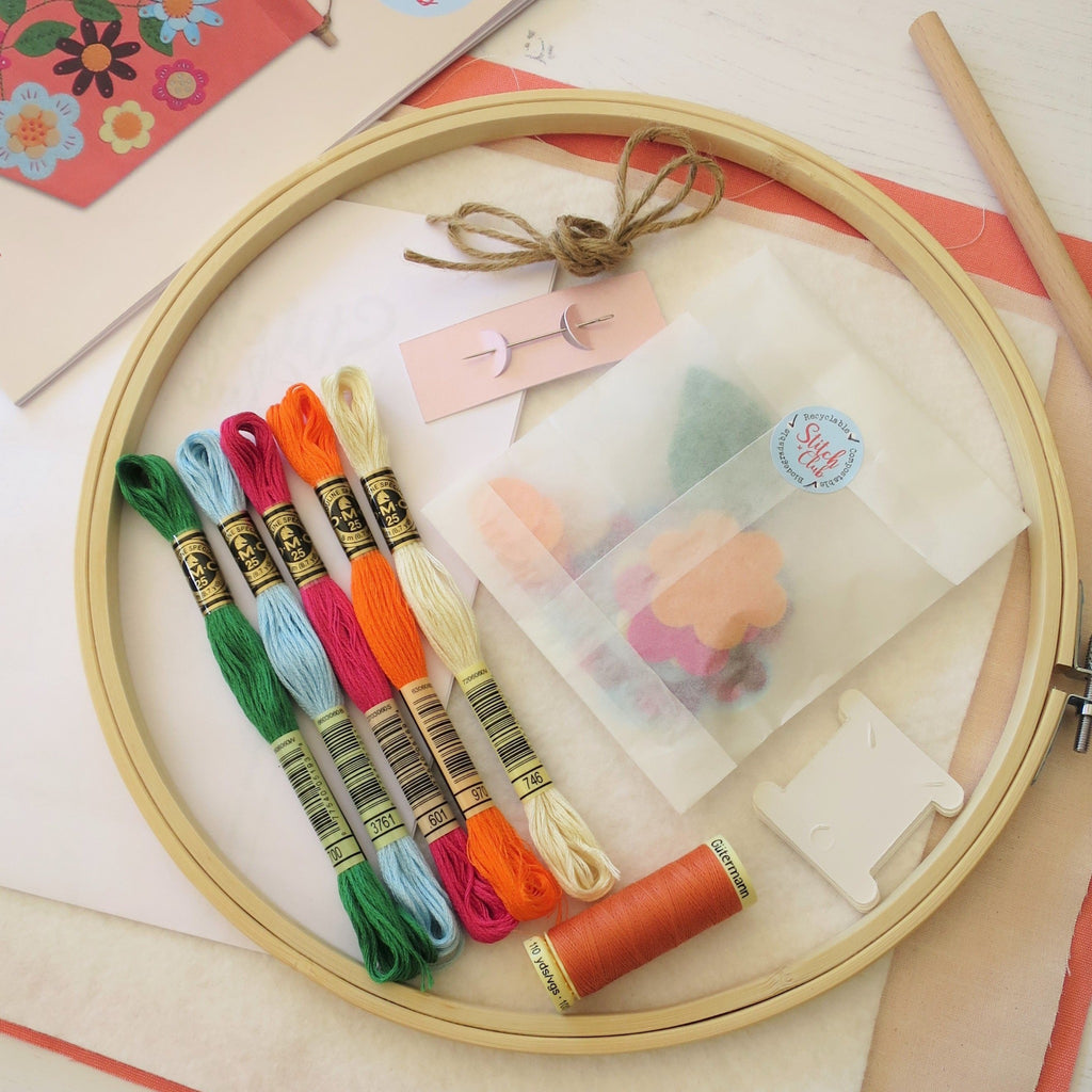 A close up of the sewing kit including a 25cm bamboo embroidery hoop with DMC cotton embroidery threads and other sewing kit supplies